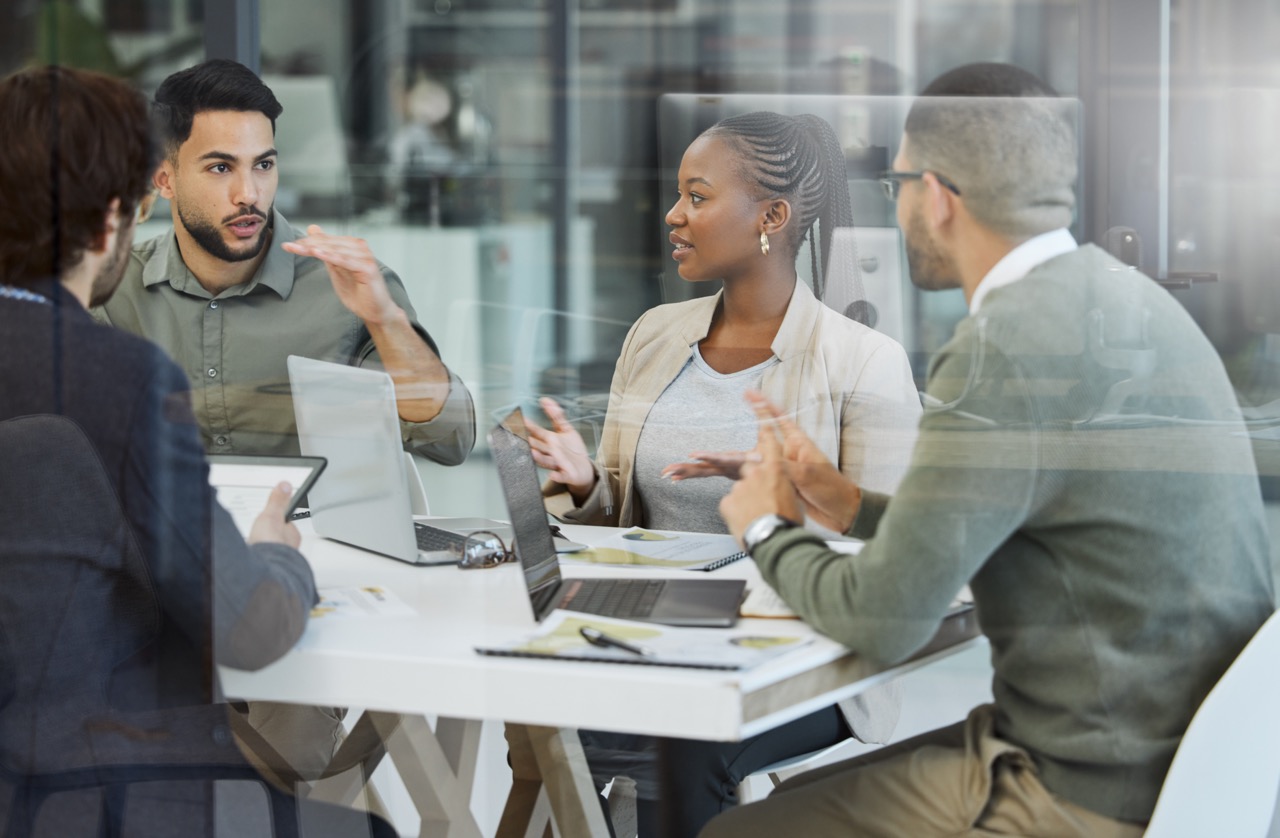 Meeting, collaboration and business people in discussion in the office while working together. Teamwork, planning and group of employees brainstorming with technology for a project in the workplace