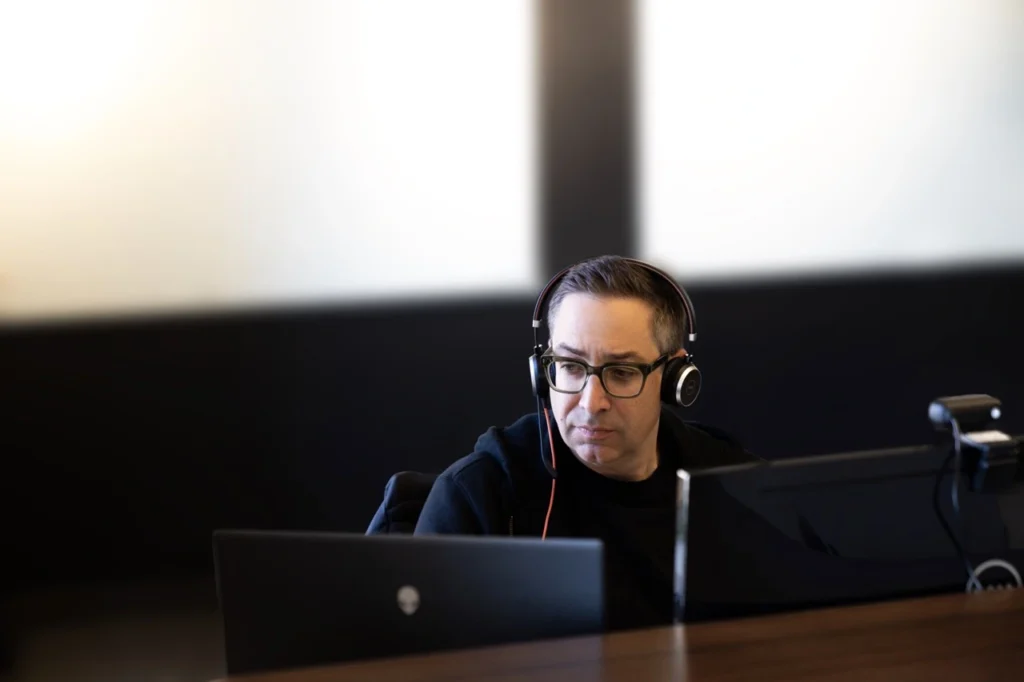 person on a computer with headphones